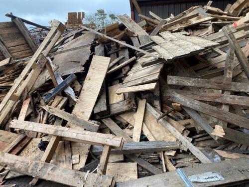 A large pile of wood, which has been dismantled from products like pallets