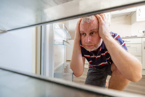 Man looking into an empty fridge