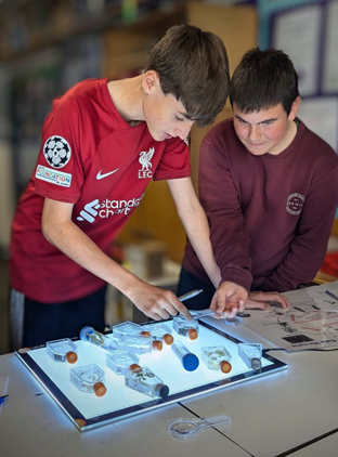 Figure 2: Pupils examining parasites on a lightbox (Image credit – Developing Young Workforce – Shetland Facebook pages).